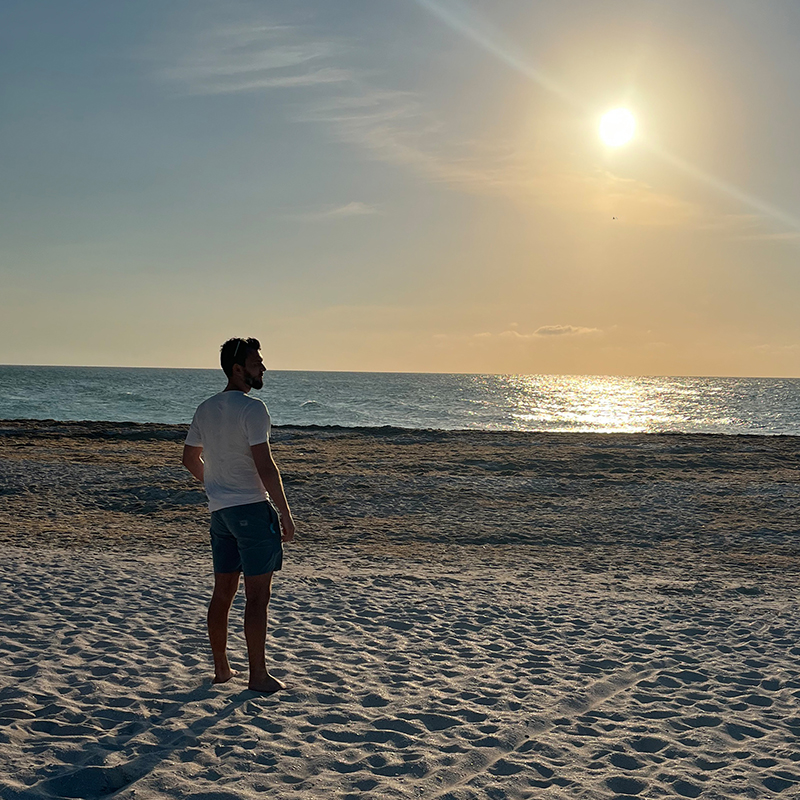 Mann am Strand bei Sonnenuntergang