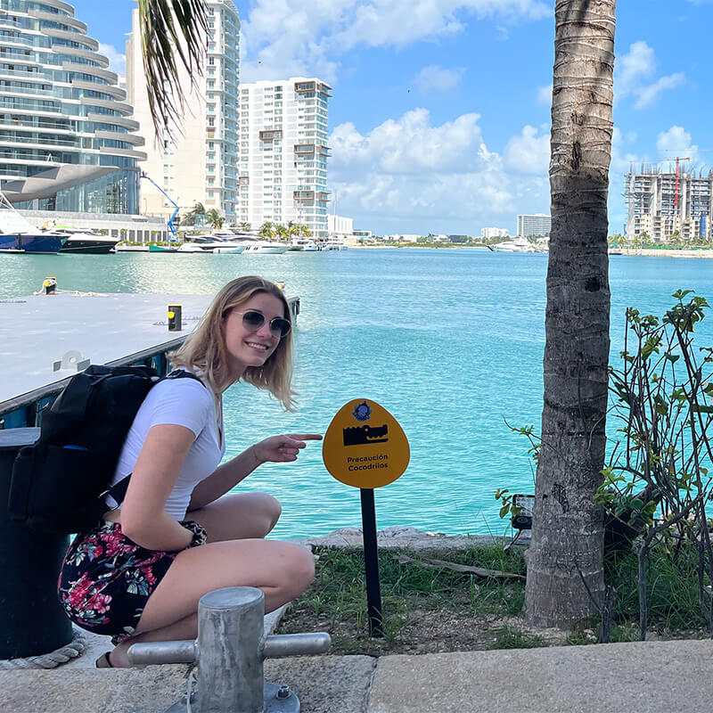 Frau zeigt auf Schild an Hafen