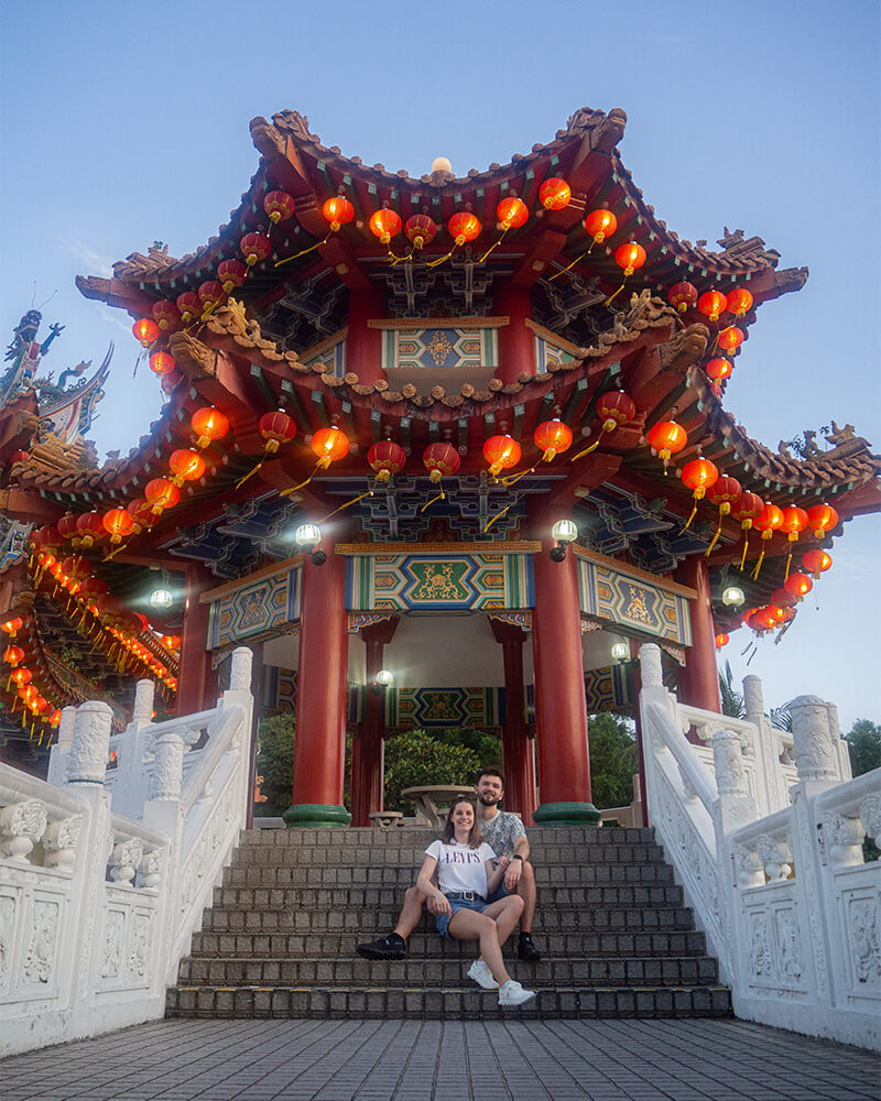 Junges Paar sitzt vor einem kleinen chinesischen Tempel 