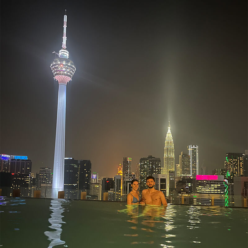 Paar im Infinity Pool vor der Kuala Lumpur Skyline 