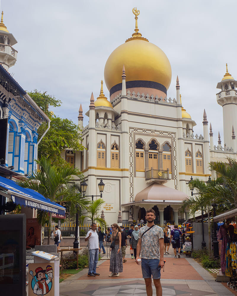 Junger Mann steht vor der Masjid Sultan Moschee