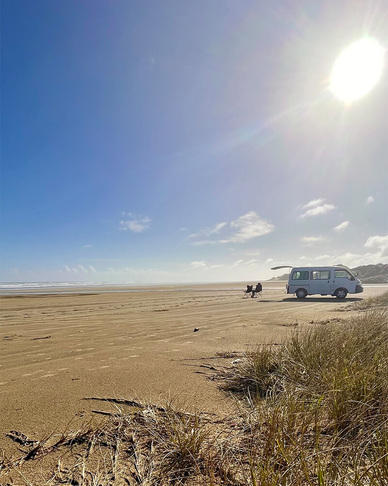 Campervan steht auf einem Strand 