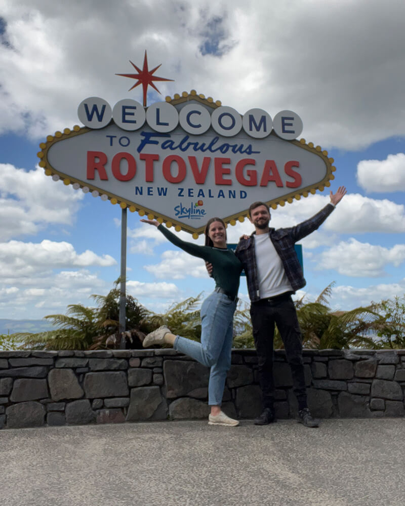 Junges Paar vor einem Schild mit der Aufschrift Welcome to ROTOVEGAS