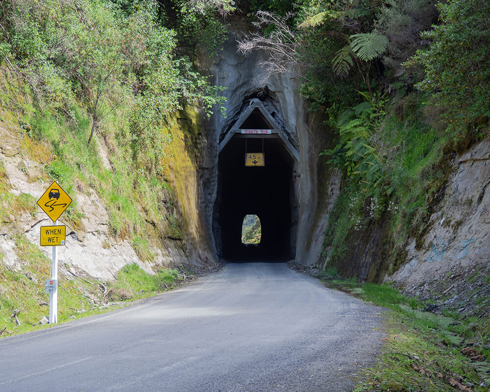 eine Straße, die in einem dünnen Tunnel in einem Berg führt