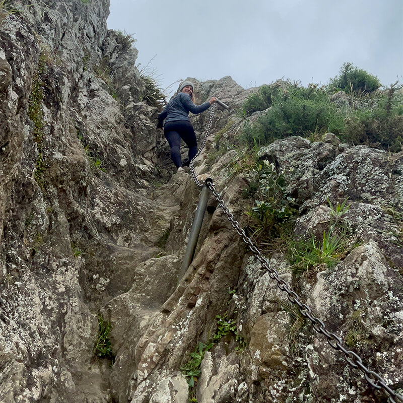 junge Frau läuft steile Felsen hinauf