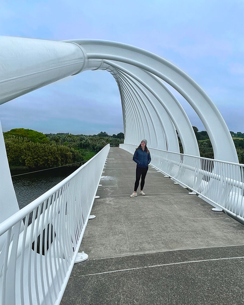 junge Frau auf einer Brücke mit weißen gebotenen Elementen