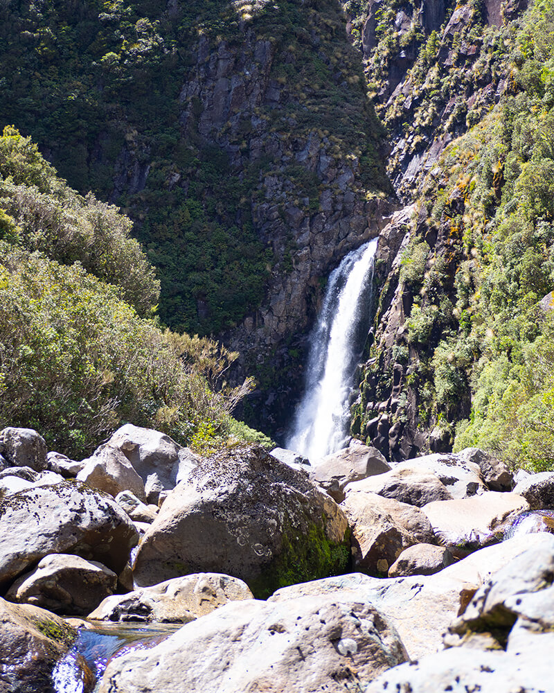 Wasserfall mit Steinen im Vordergrund