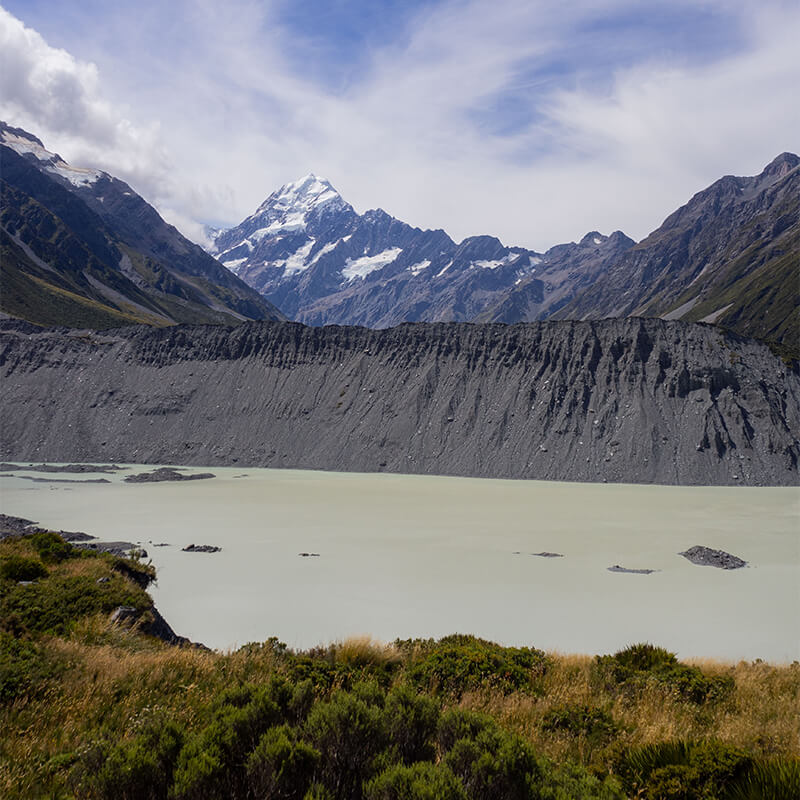 Gletschersee im Vordergrund, mit Bergen im Hintergrund