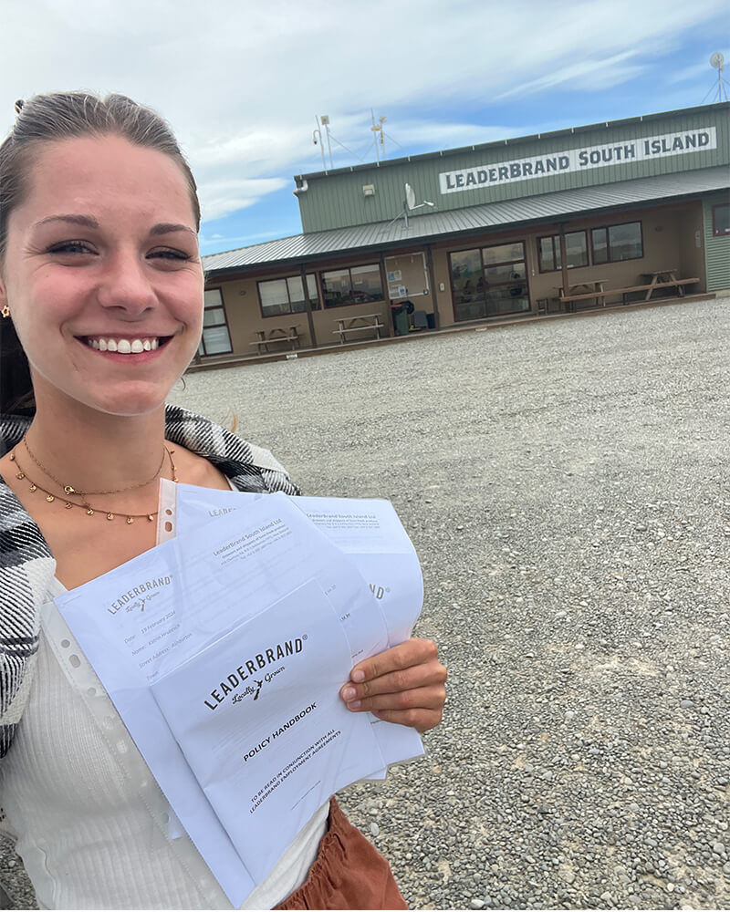 Selfie von einer jungen Frau die Arbeitsverträge in der Hand hält
