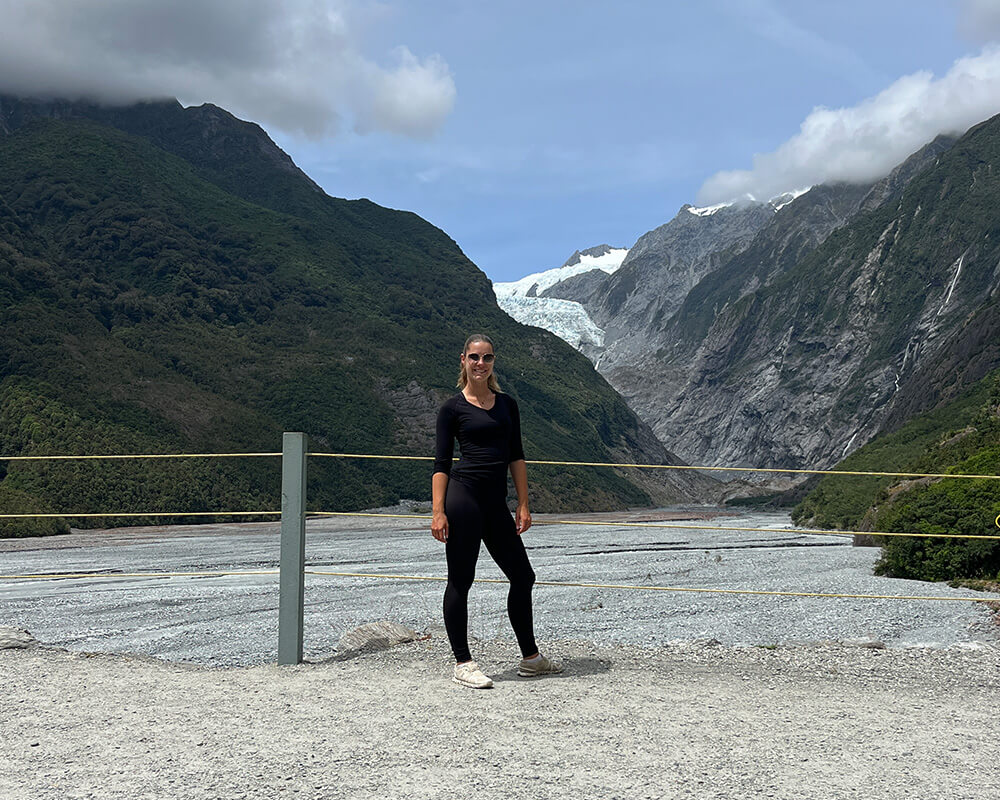 Junge Frau mit dem Franz Josef Gletscher im Hintergrund